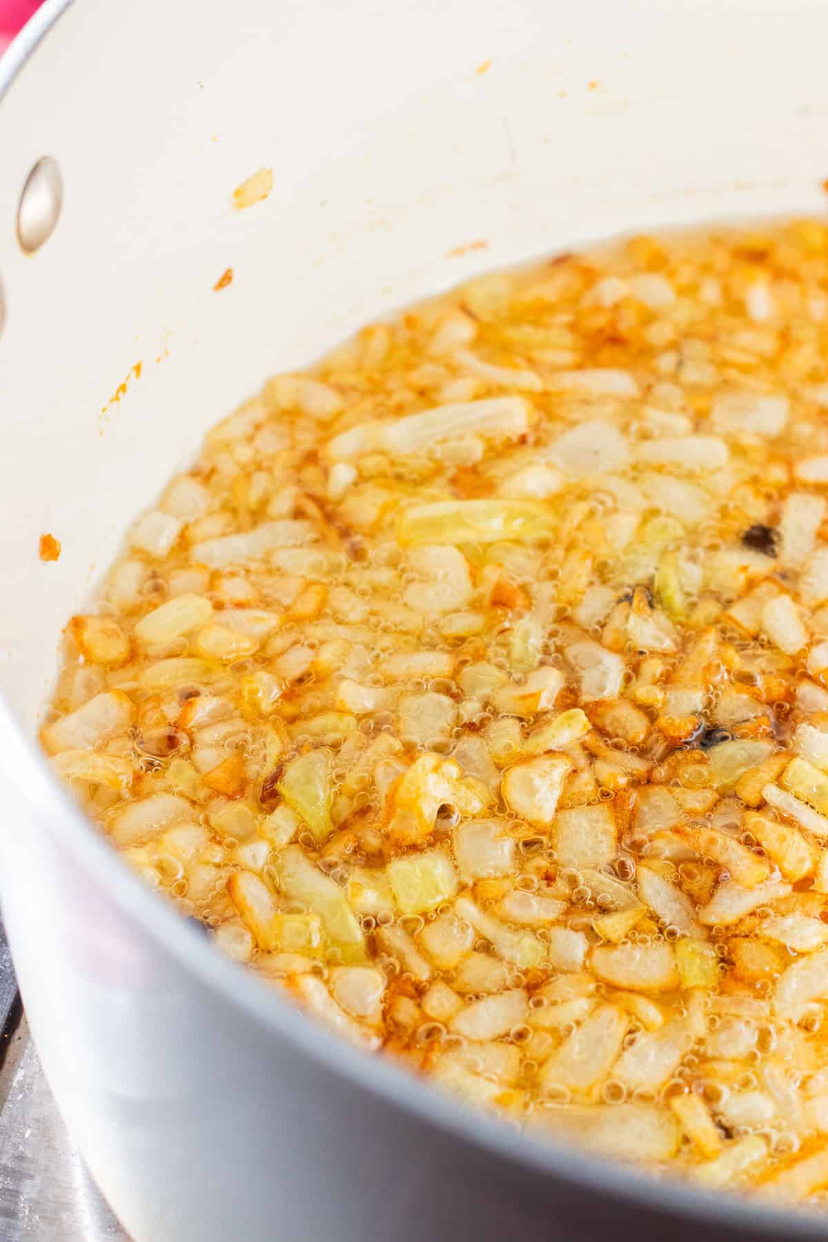onions being lightly caramelized for aloo gosht.