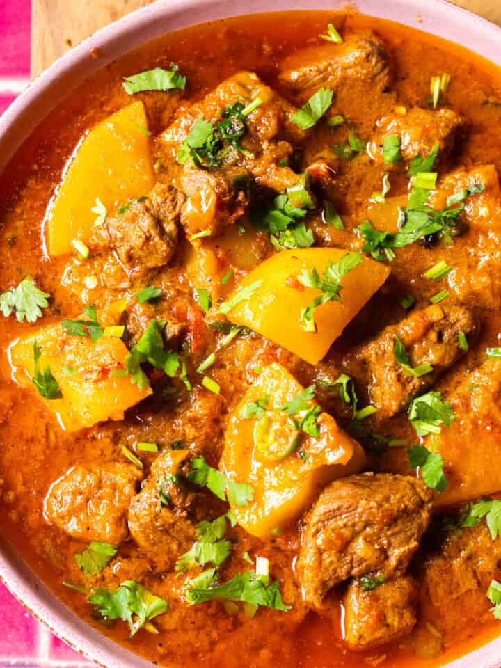 A bowl with Aloo Gosht, a meat and potato stew.