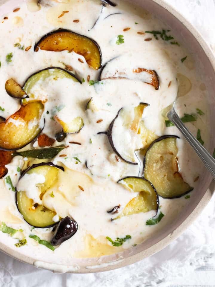 top down view of dahi baingan with sliced cooked eggplant peeking through