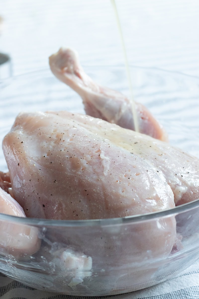 marinade for the roast being poured onto a chicken 