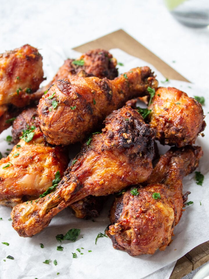 ¾ view of a a board with chicken drumsticks on top