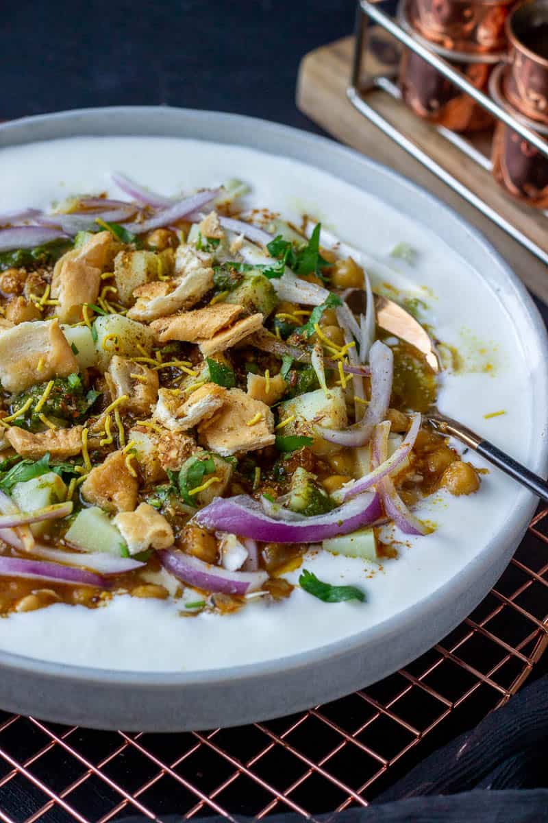 ¾ view of a plate of chaat with a spoon in it