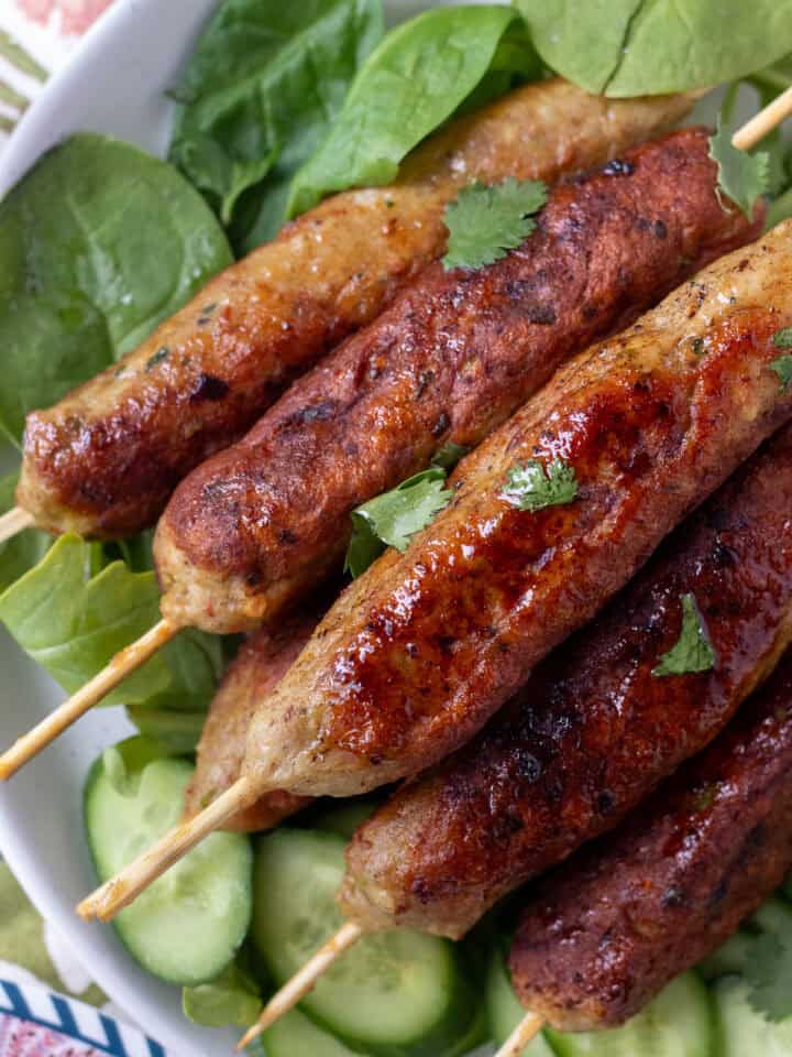 chicken seekh kabab on a plate with greens