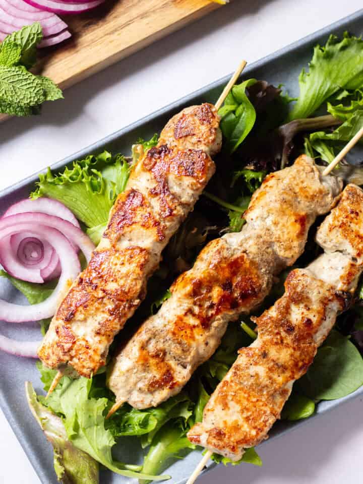 chicken seekh kabab on a bed of greens